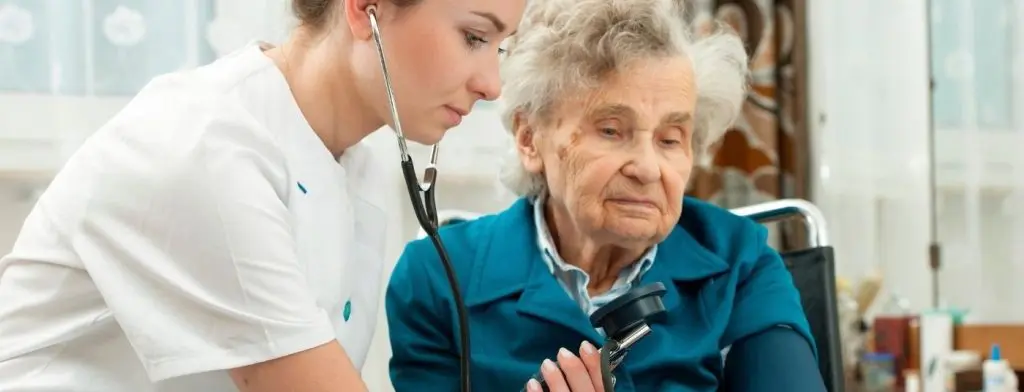 nurse taking blood pressure of elderly woman
