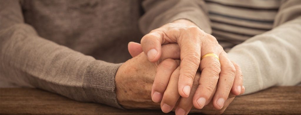 Elderly married couple holding hands