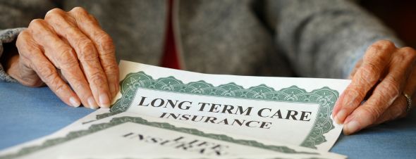 person's hands on long-term care insurance document
