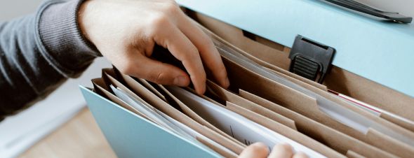 hands paging through file folder