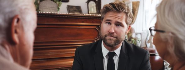 man discussing funeral plans with elderly couple