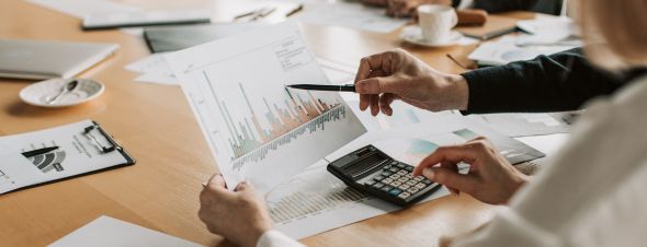 people discussing documents with calculator