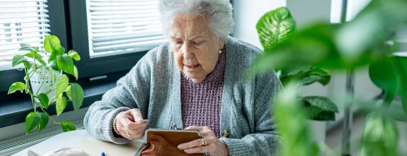 elderly woman looking through coin purse