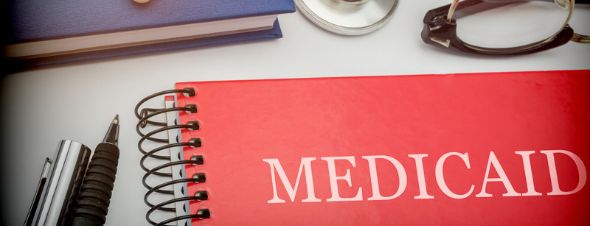 Medicaid book with pens on desk