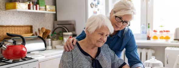 adult daughter viewing documents with elderly mother