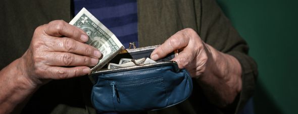 elderly woman handling money in coin purse